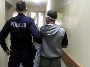 Policjant podczas doprowadzania zatrzymanego do komisariatu