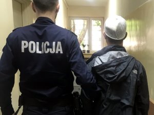 Policjant podczas doprowadzania zatrzymanego do komisariatu