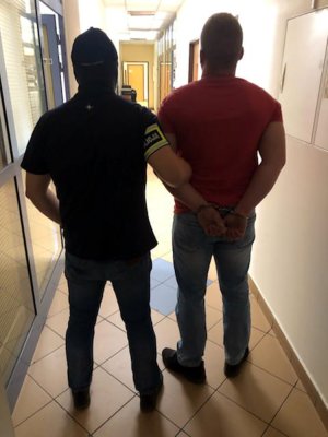 Policjant podczas doprowadzenia zatrzymanego do komendy