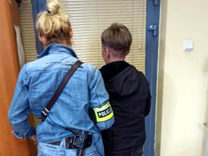 Nieumundurowana policjantka w trakcie doprowadzenia zatrzymanej kobiety do jednostki Policji