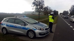 Policjant ruchu drogowego dokonujący pomiar prędkości podczas prowadzonych działań