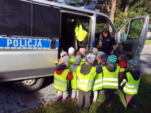 Policjantka  prezentuje dzieciom policyjny radiowóz