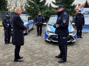 Komendant z policjantami oraz Starosta Warszawski Zachodni podczas uroczystego przekazania oznakowanego radiowozu