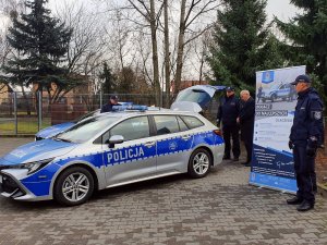 Komendant z policjantami oraz Starosta Warszawski Zachodni podczas uroczystego przekazania oznakowanego radiowozu