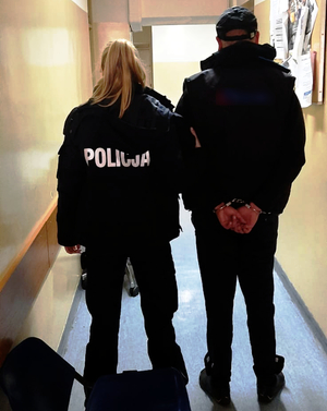 Policjantka prowadzi zatrzymanego mężczyznę