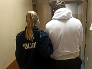 Umundurowana policjantka doprowadza zatrzymanego mężczyznę na czynności procesowe