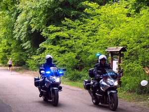Umundurowani policjanci na motorach zabezpieczają trasę biegu