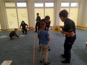 Dzieci wykonują poszczególne zadania pod nadzorem policjantów