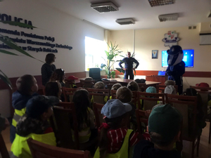 Dzieci podczas spotkania w sali odpraw z dzielnicowym i policyjnym Borsukiem, maskotką stołecznej Policji