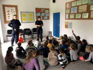 Policjanci w sali edukacyjnej prowadzą spotkanie z dziećmi