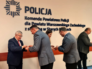 Uczestnicy spotkania opłatkowego w komendzie. dzielenie się opłatkiem