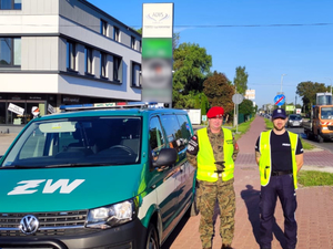 Policjant razem z funkcjonariuszem Żandarmerii Wojskowej obok oznakowanego radiowozu