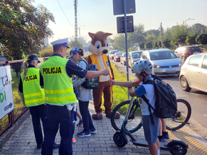 Policjanci rozdają elementy odblaskowe dzieciom idącym do szkoły