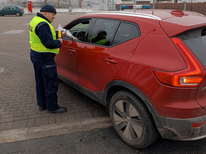 Policjant po przeprowadzonym badaniu trzeźwości przekazuje kierowcy zestaw z odblaskowymi gadżetami