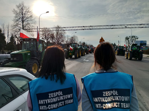 Policjanci zabezpieczają przejazd  kolumny maszyn rolniczych po drodze krajowej 92