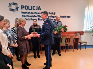 Komendant wręcza kwiaty pracownicom komendy z okazji 8 marca