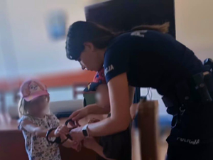 Policjantka prezentuje przedszkolakom kajdanki