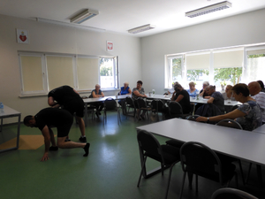 Policjanci podczas spotkania z seniorami pokazują sposoby obrony przed napastnikiem