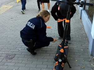 Policjantka przekazuje odblaski kierującemu hulajnogą