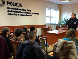 Uczniowie podczas spotkania z policjantem w komendzie