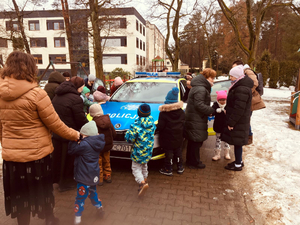 Dzieci na tle oznakowanego radiowozu podczas jego prezentacji